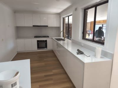 Modern white kitchen with stone benchtop, tiled splashback and integrated appliances